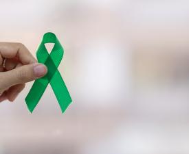 Hand holding green ribbon